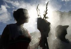 RITUAL DE FIN DE AÑO. Una seguidora de la religión Umbanda carga un ramo de flores para 'Iemanjá', la reina del mar, en la playa de Copacabana en Río de Janeiro (Brasil). Es tradición brasileña en época de fin de año el homenaje a Iemanjá con una pro