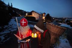 VISITA ADELANTADA. Un hombre disfrazado de San Nicolás y su ayudante Schmutzli se preparan para visitar a los niños en Hergiswil, Suiza.