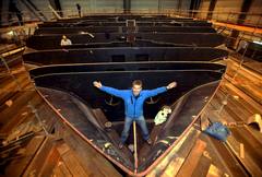 INNOVACIÓN SOBRE EL MAR. El escalador y marinero suizo Raphäel Domjan posa frente al catamarán en construcción que funcionará con la sola fuerza de la energía solar, que dará la vuelta al mundo, en el astillero de Knierim en Kiel, Alemania.