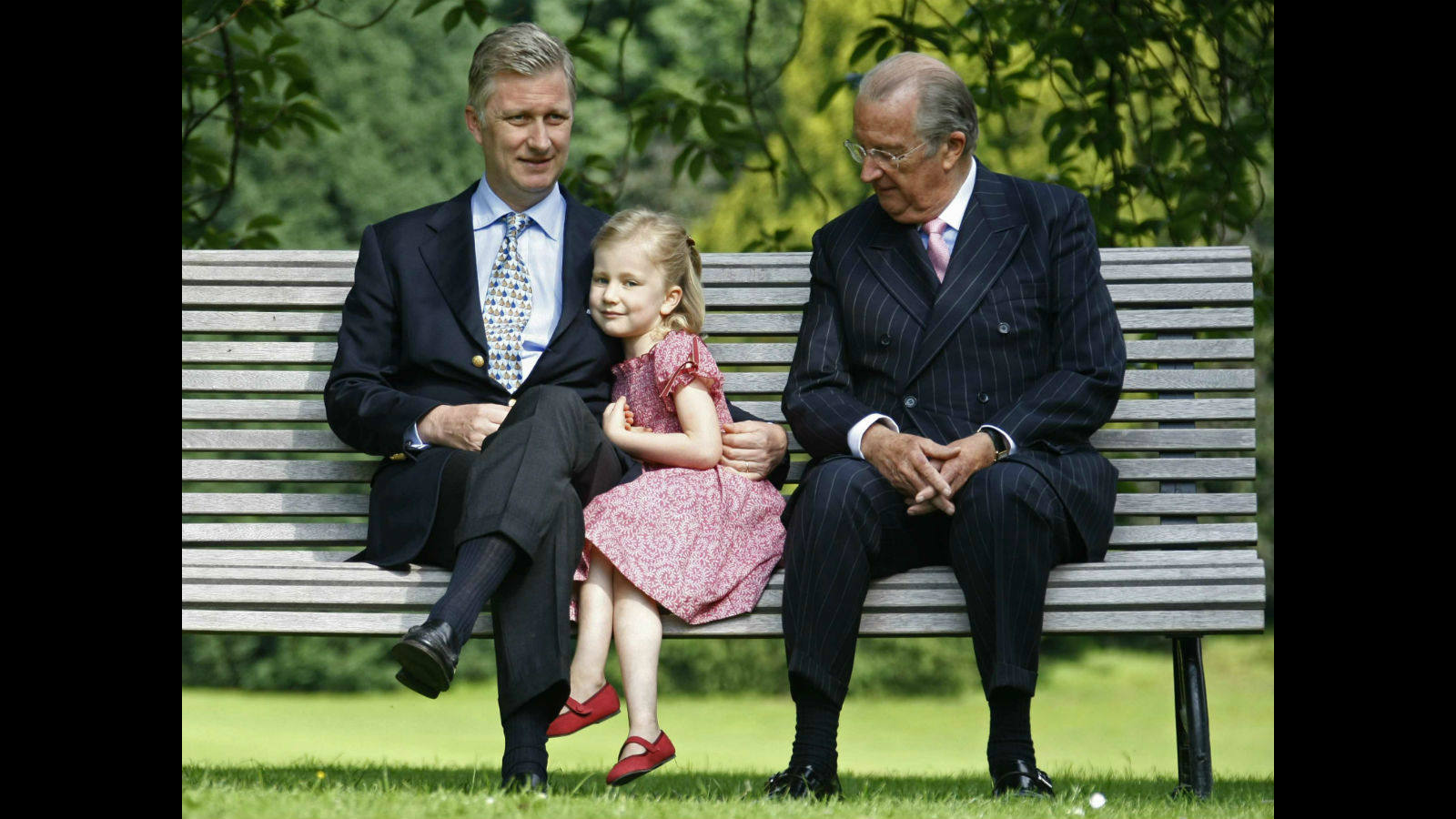 El Príncipe Philippe, su hija Elisabeth y el Rey Alberto II en un banco en los jardines de Laeken.