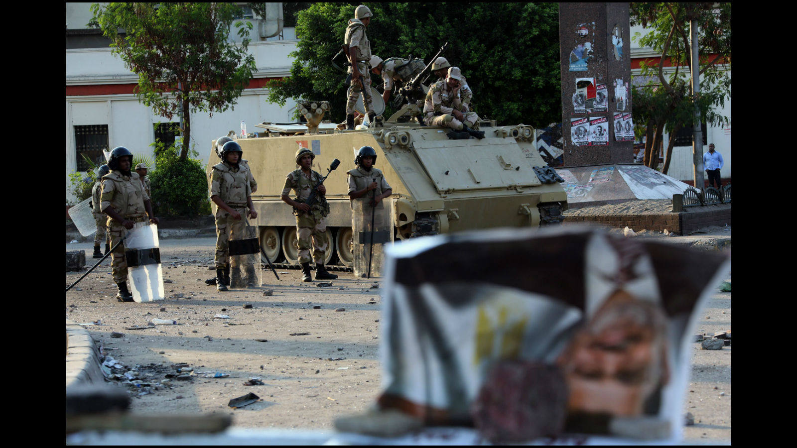 Un cartel invertido del presidente depuesto ha aparecido tirado frente a un grupo de militares