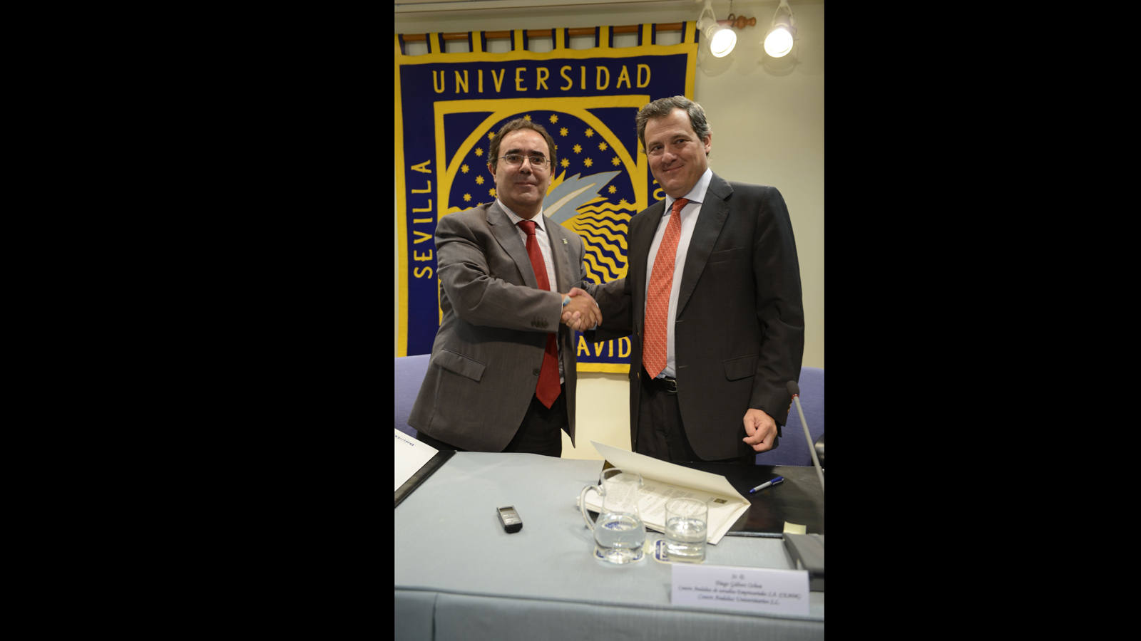 El rector de la UPO, Vicente Guzmán, y el director general de Ceade, Diego Gálvez, firman el acuerdo por el que Ceade funcionará como centro adscrito de la Olavide a partir de 2014-2015