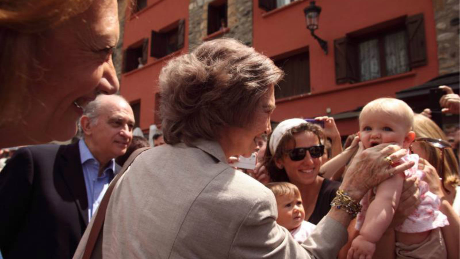 Doña Sofía saluda cariñosamente a un bebé durante su visita a las zonas afectadas por las inundaciones