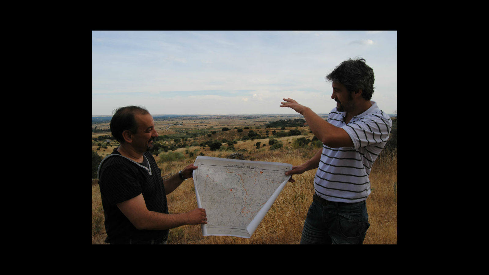 Ángel Rodríguez (izq) y Ernesto Viñas (der) comparan un mapa de época con una vista general del campo de batalla en el que se libraron los combates.